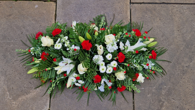 Funeral coffin spray in red and white, lilies, roses, carnations