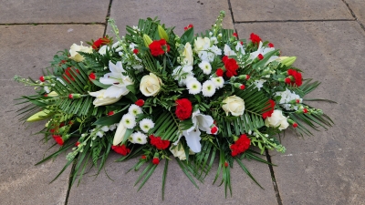 Funeral coffin spray in red and white, lilies, roses, carnations