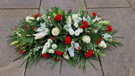 Funeral coffin spray in red and white, lilies, roses, carnations